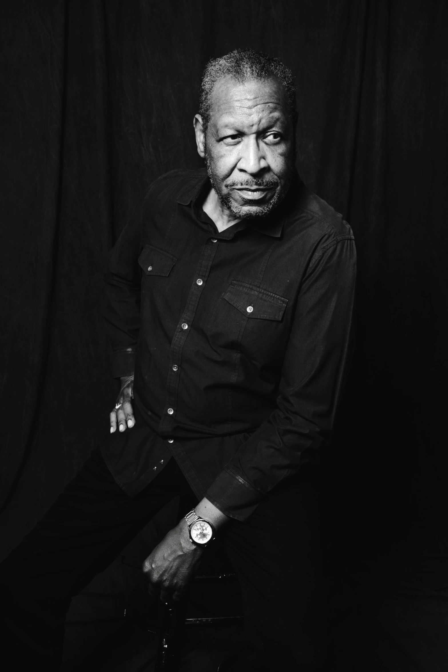 a black and white po of a man leaning on a chair