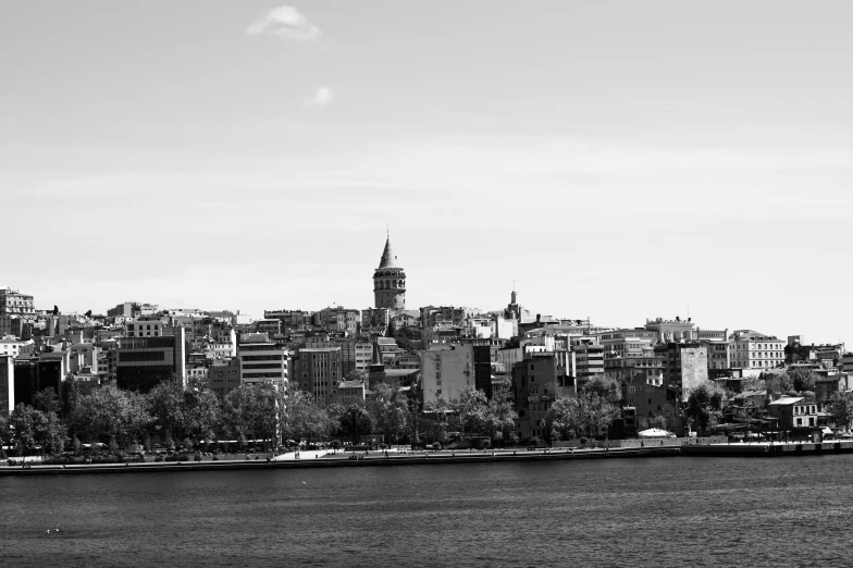 black and white pograph of city skyline with lake and sailboat