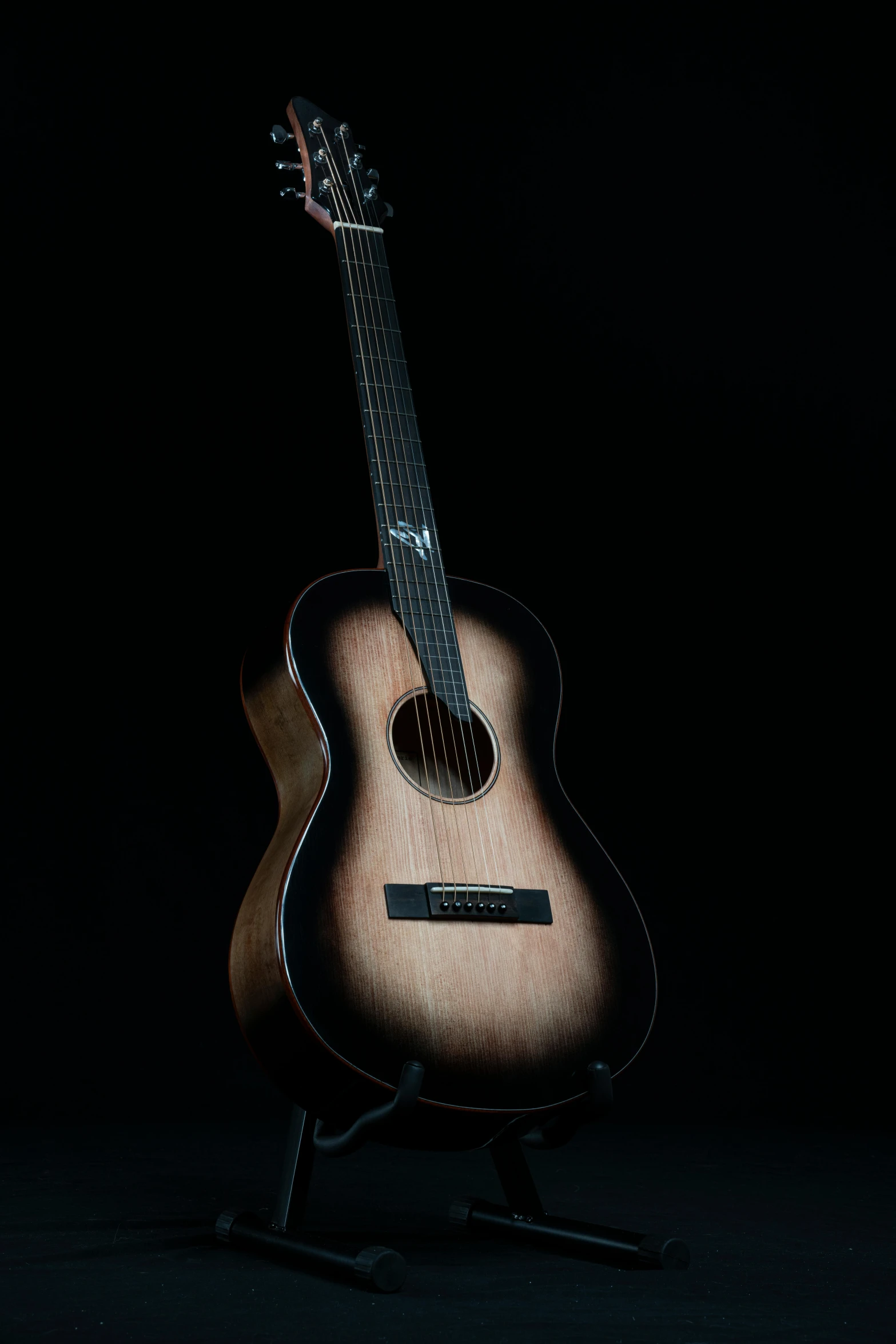 a guitar is sitting up against a black background