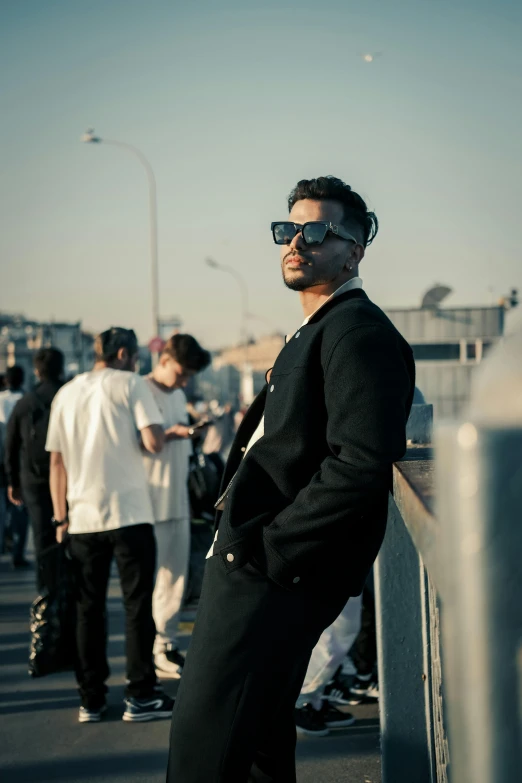a man wearing sunglasses on a bridge posing