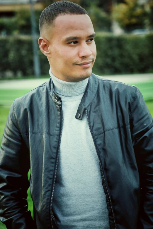 man in black jacket standing outside at park