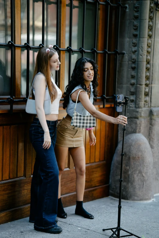 two women taking a picture outside on the street