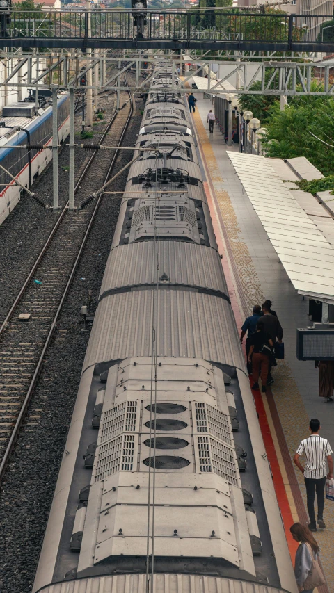 train passengers walking on platform near elevated train tracks