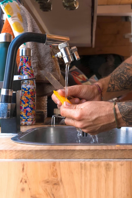 someone washing their hands under a bathroom sink