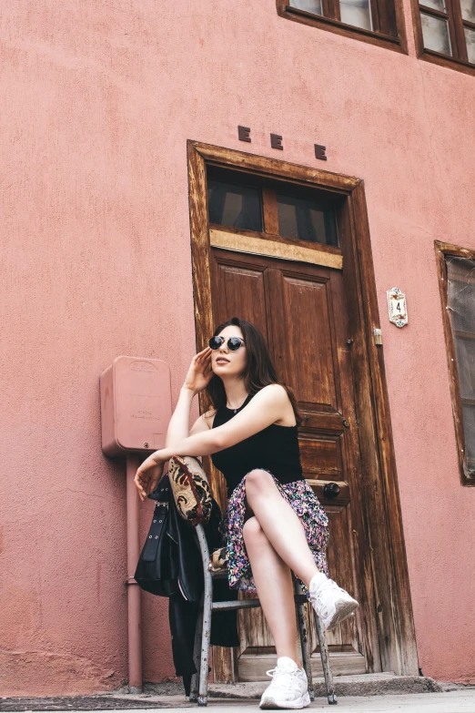 a beautiful young woman in a short dress sitting on a chair