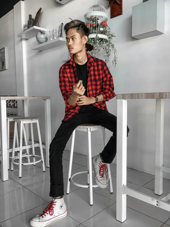 young asian boy sitting on a stool in a room