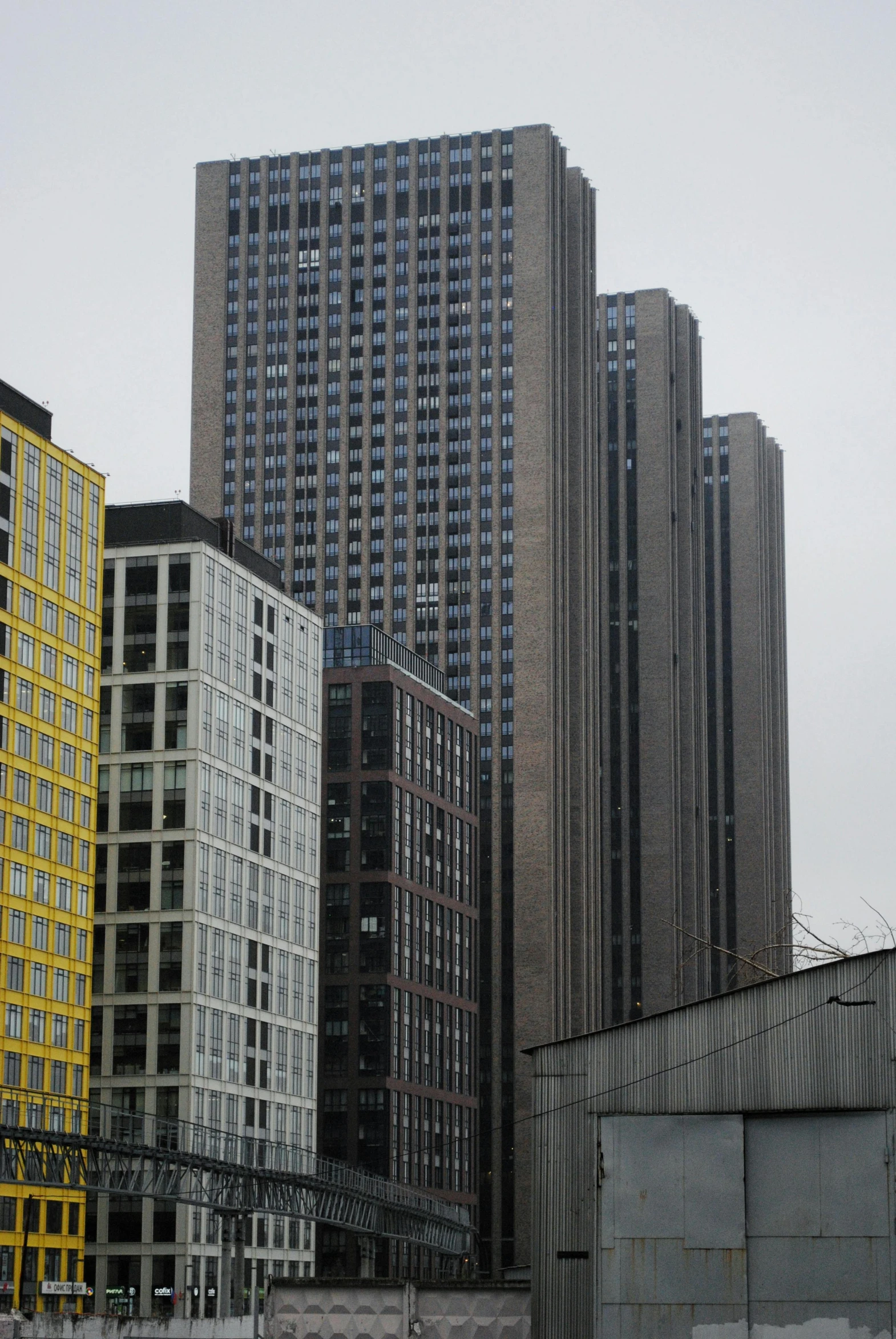 many tall buildings and a train track against a sky background