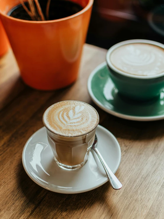 two cups of coffee on a table next to pots