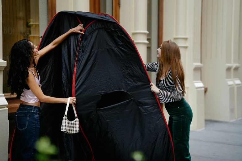 two women placing a tent on the ground