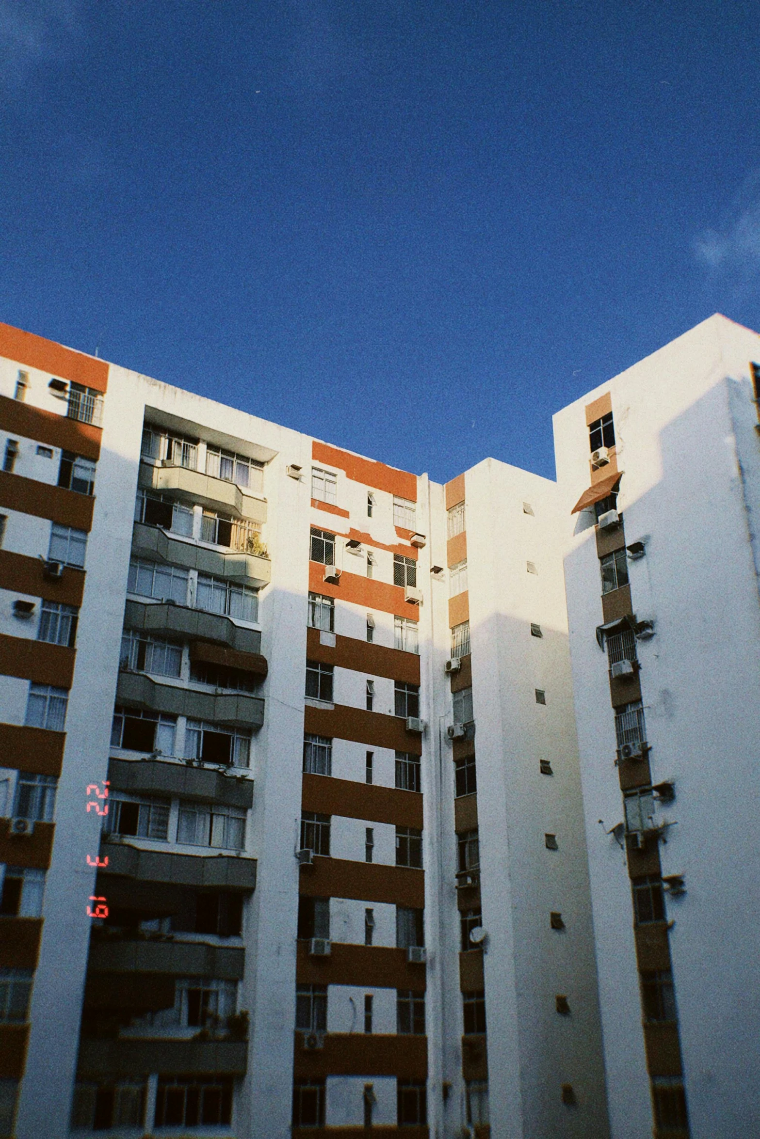 the white, red, and beige high rise apartment buildings