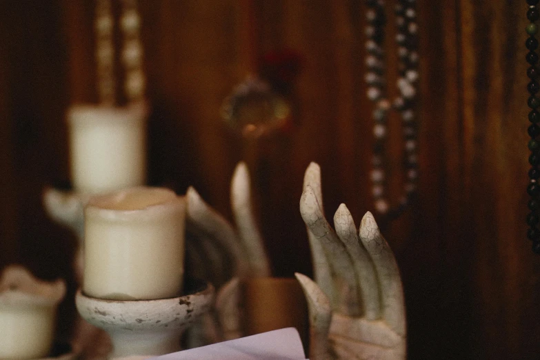 two hands reaching out from candles in front of a sign