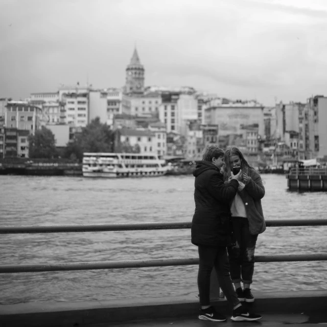 two people on a bridge near the water