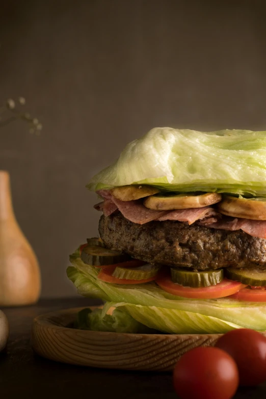 an enormous hamburger with tomatoes and cucumbers