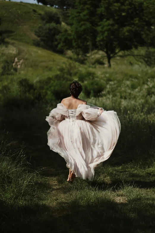 a woman in a white dress walking on grass