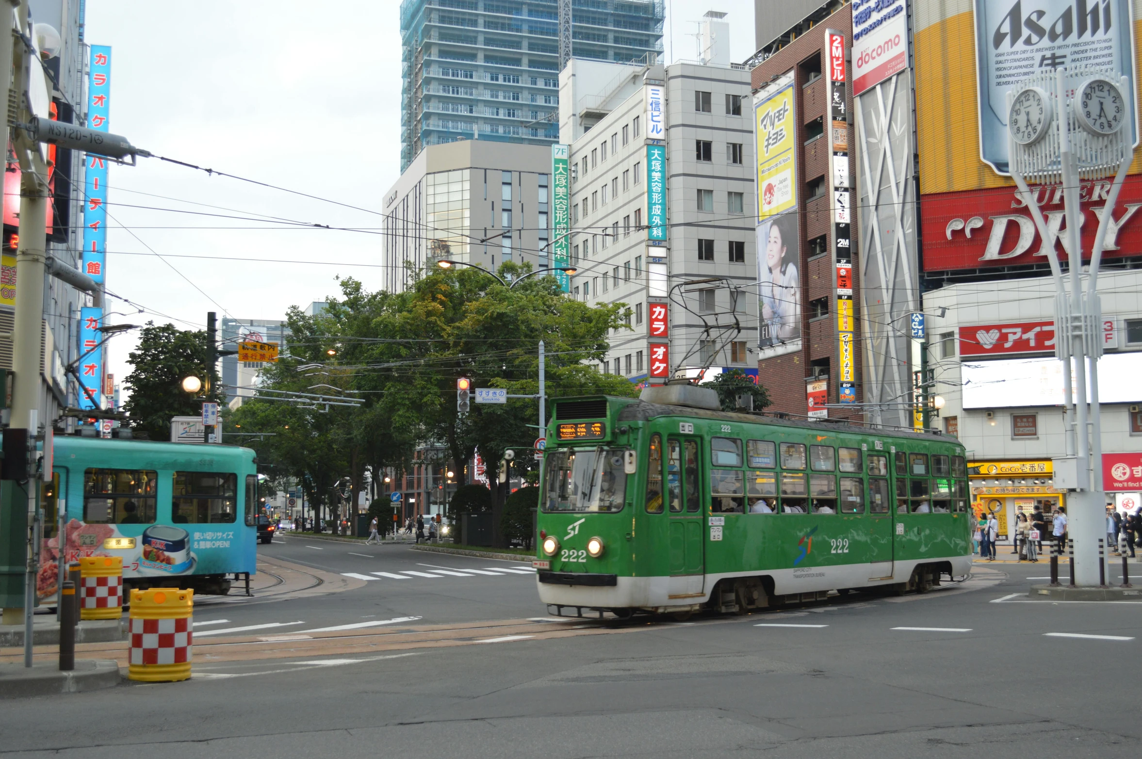 a green trolley in a busy city intersection