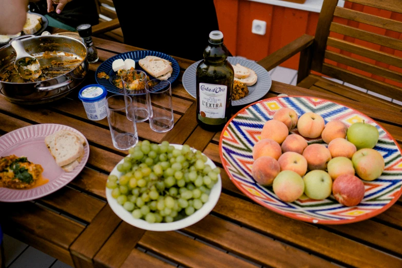 a picnic table set with several plates of fruit