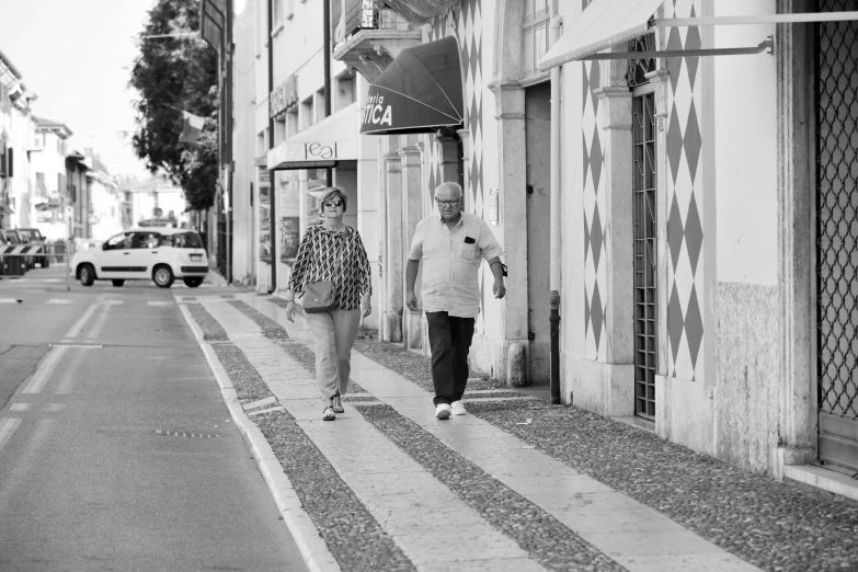 a man and woman walking down the street together