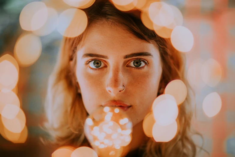 a woman with bright eyes and blurry lights