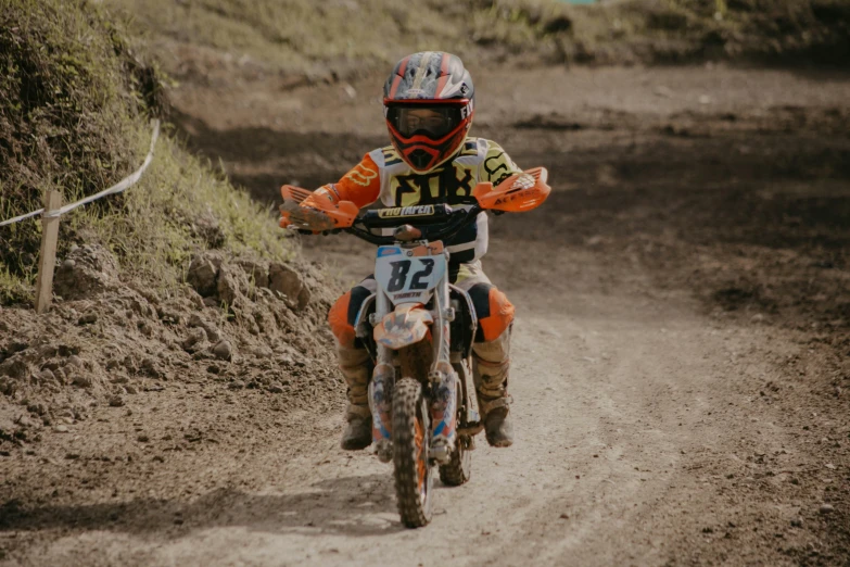 a dirt bike rider races around the bend of a dirt road