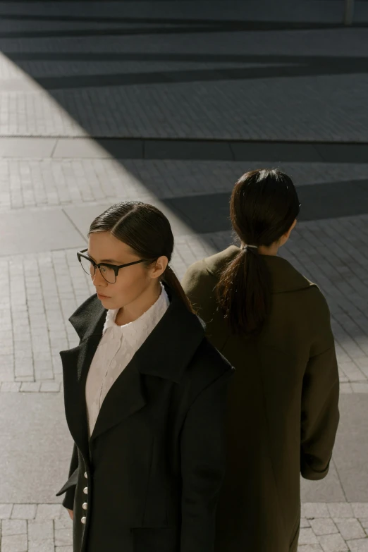 two woman walking down the street in the sun