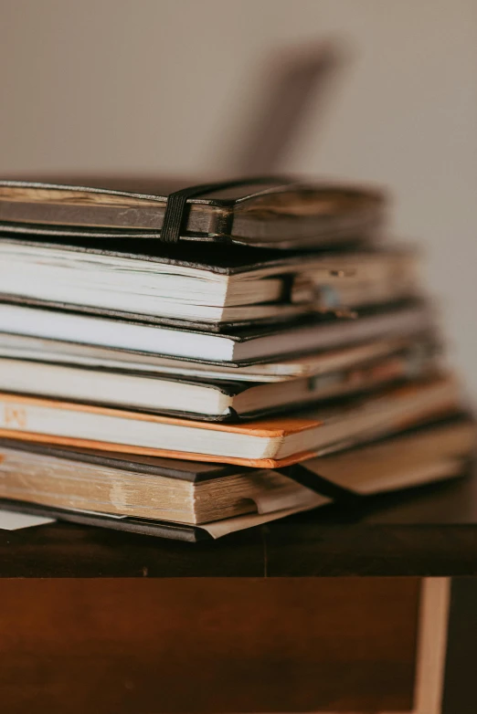 an old stack of books on top of a wooden table