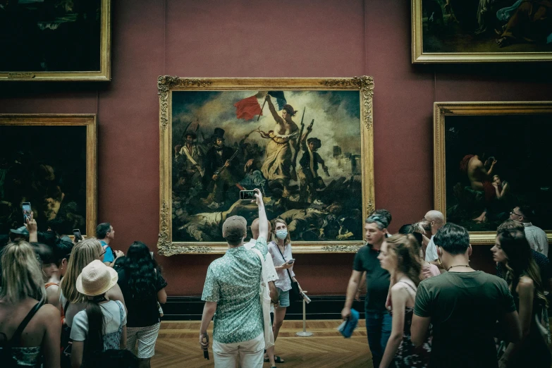 group of people in front of painting in an art gallery