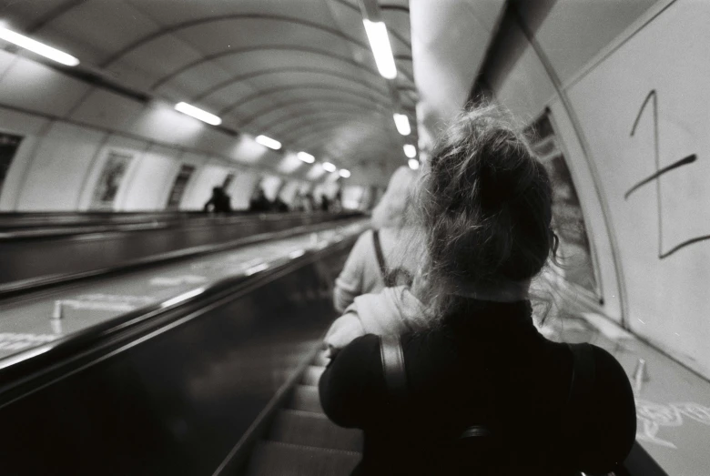 woman moving down escalator in public transportation