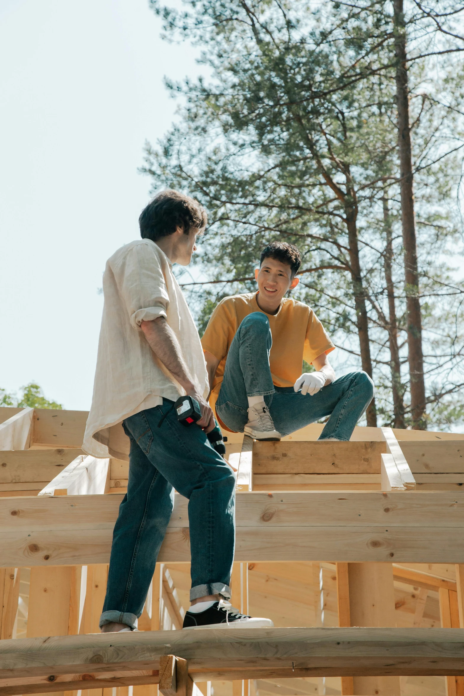 two men standing on top of wood frame construction