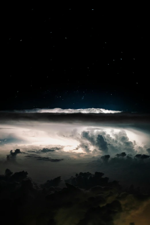 the night sky with white clouds and stars above