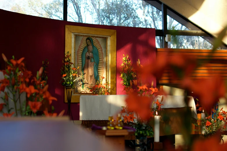 small flowers are placed near an altar in front of a virgin