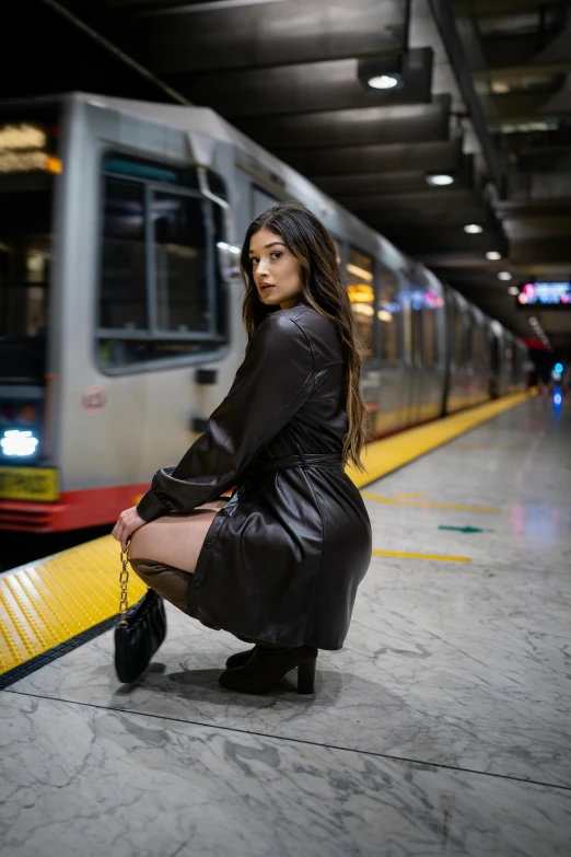 a woman with a coat on is near a train