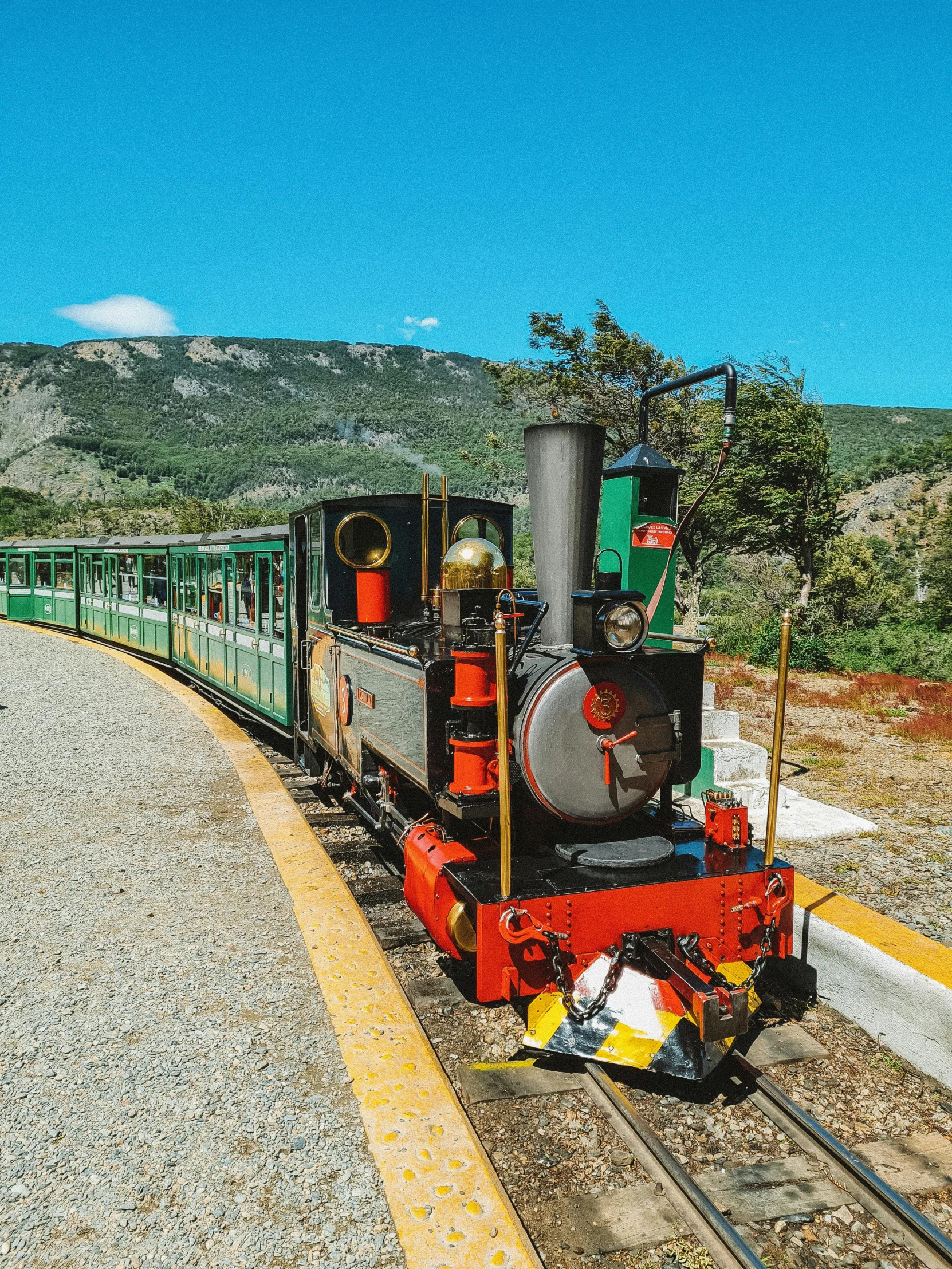 a green and red train engine sitting on top of a track