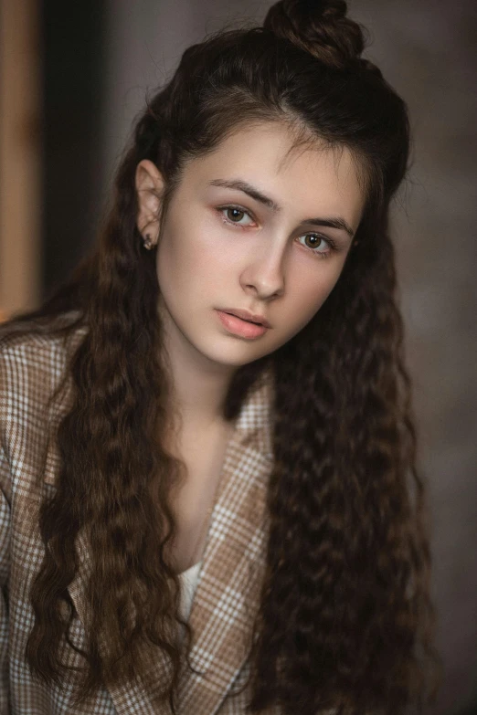 a young woman with long brown hair in a suit