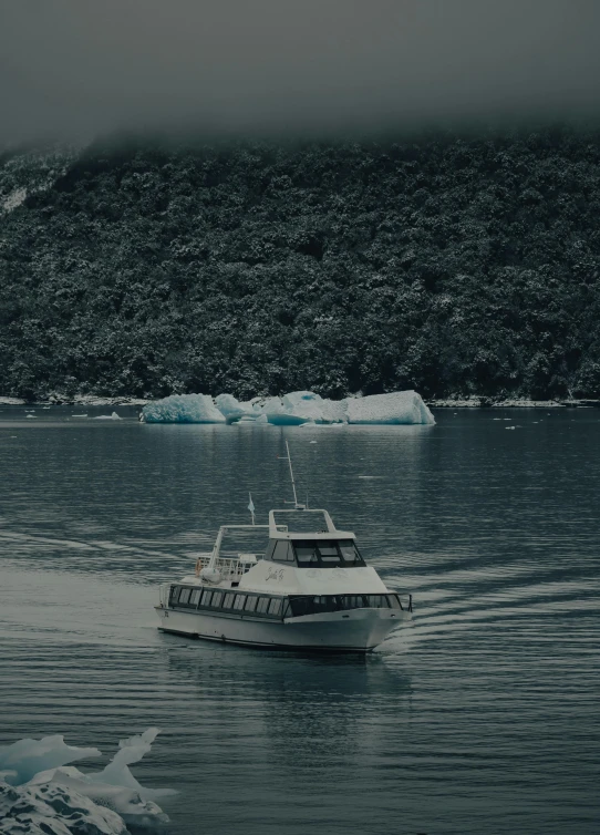 a small boat floating in front of an iceberg