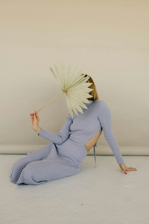 a woman sitting on the floor while holding a stick