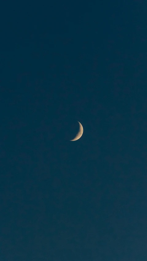 the moon is visible in the sky just before sunrise