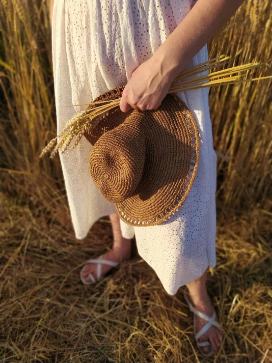 a woman in white dress standing next to a grassy field