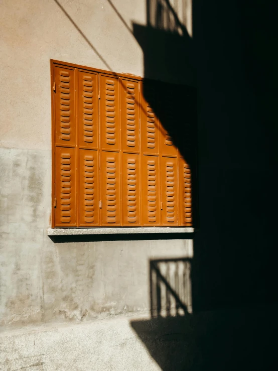 a tan window with yellow shutters and an open window