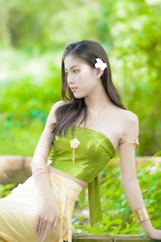 a women with a flower in her hair sitting on a bench