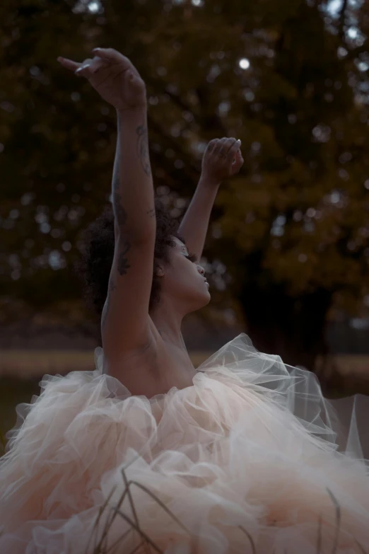 the  in the white dress is holding her arms up