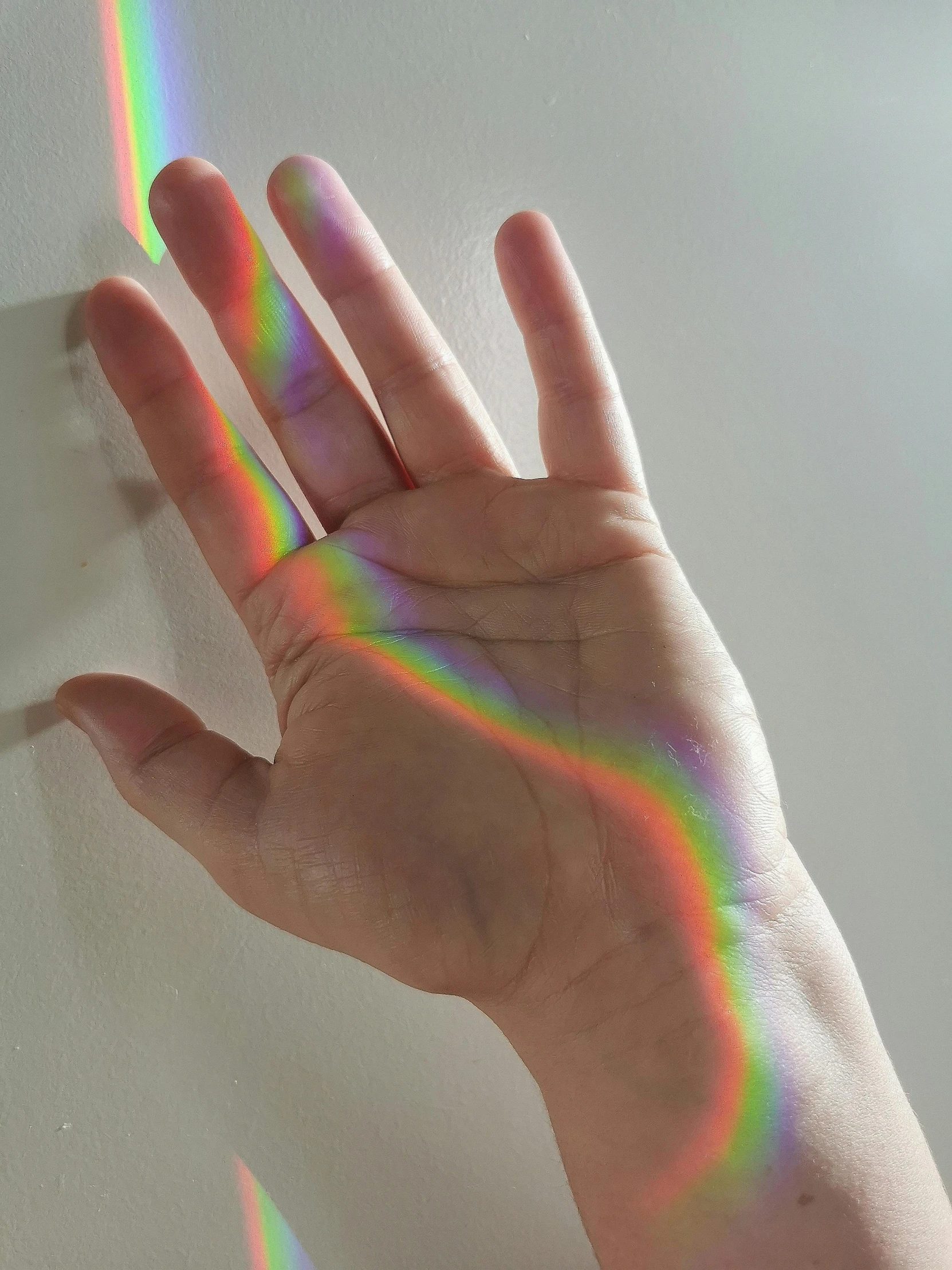 the hand is in front of a rainbow pattern