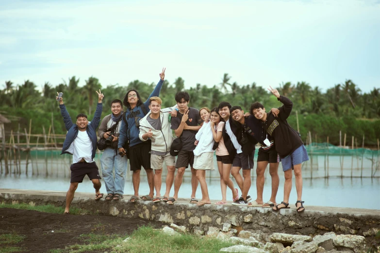 a group of people standing next to each other on top of a rock