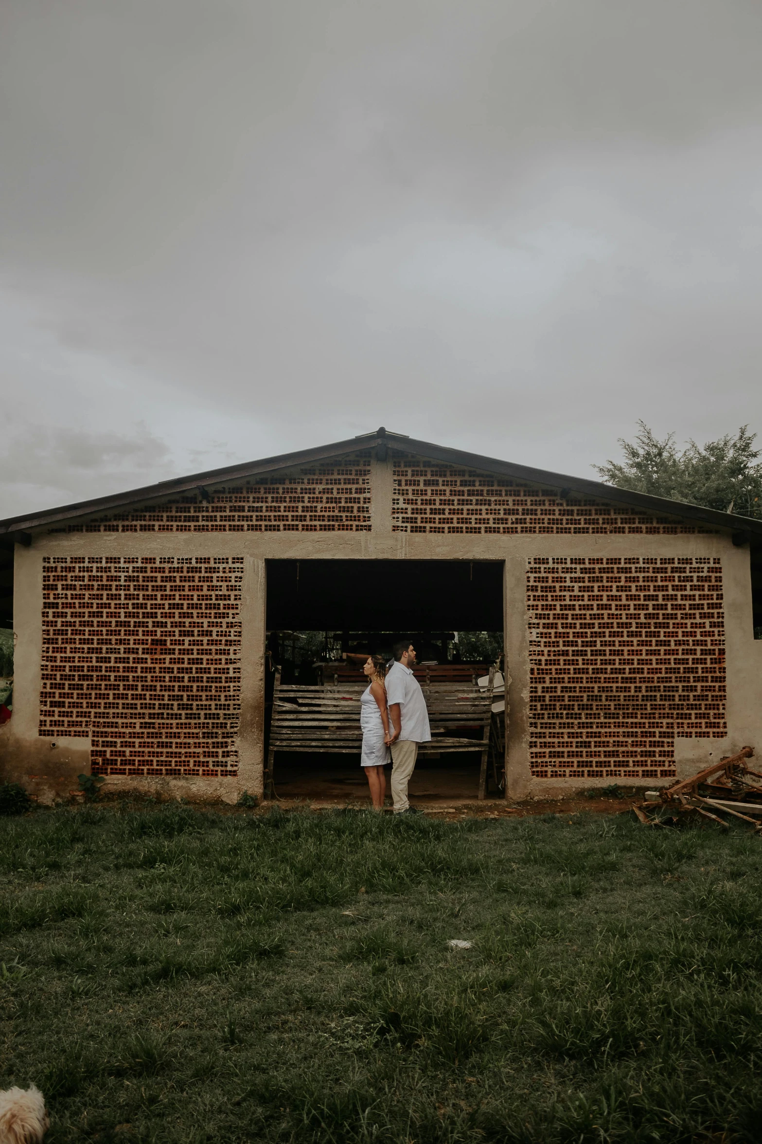 the bride and groom walk outside their barn