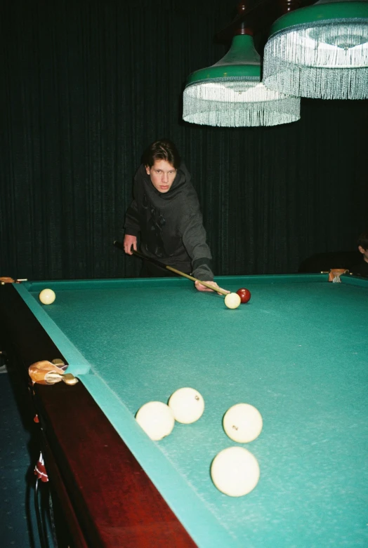 a person is leaning over a pool table