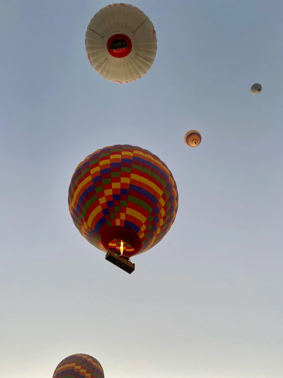 a group of  air balloons float in the sky