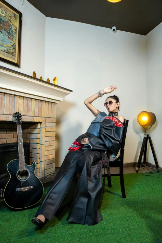 a man sitting in a chair with his guitar next to him