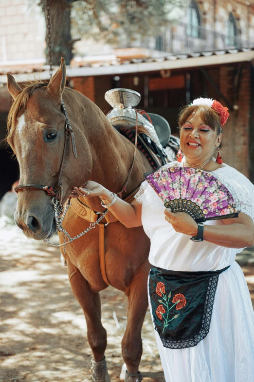 a woman with a fan standing beside a horse