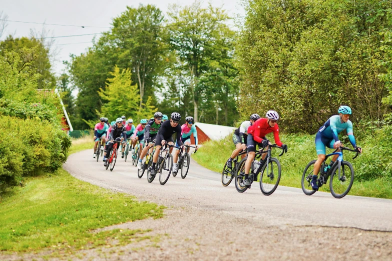 men riding their bikes down a paved road