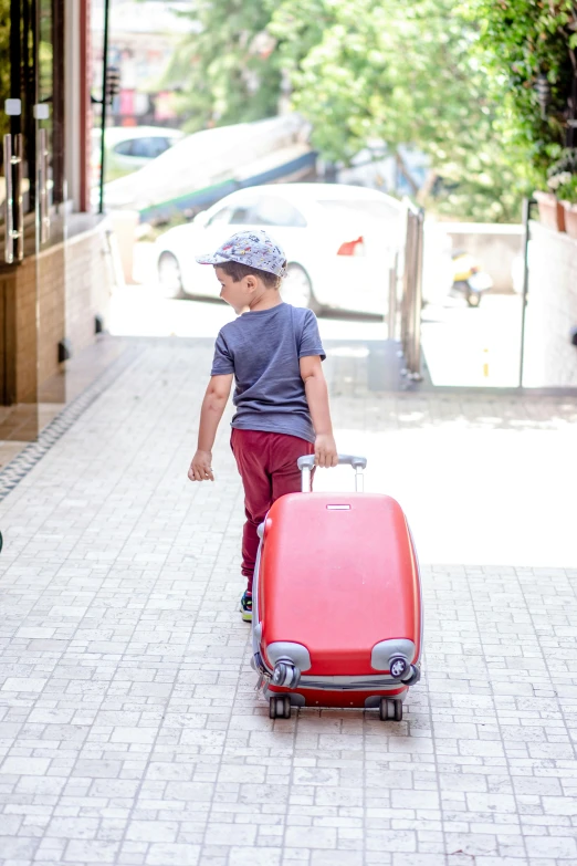 a  riding on a skate board pulling a luggage case