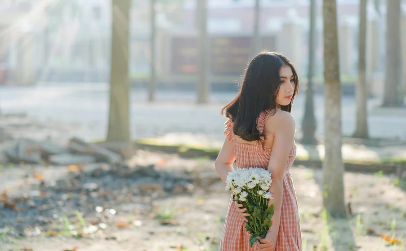 a woman holding a bouquet of white flowers